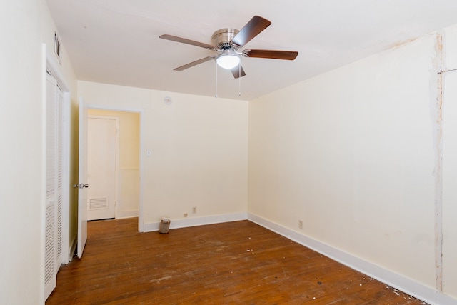 empty room with ceiling fan and dark wood-type flooring