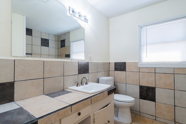 bathroom with tile walls, tile patterned flooring, vanity, and toilet