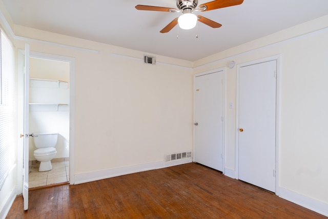 unfurnished bedroom with dark hardwood / wood-style flooring, ceiling fan, and ensuite bathroom