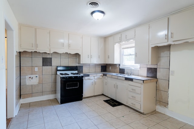 kitchen with white cabinets, light tile patterned flooring, and black range with gas cooktop