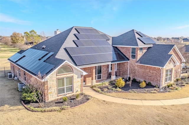 view of front of home featuring central AC and solar panels