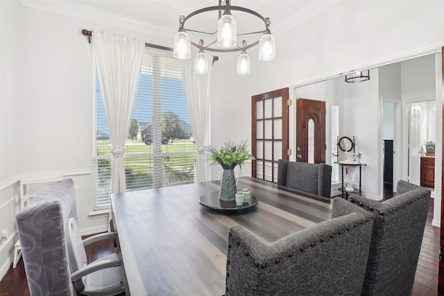 dining area with ornamental molding, hardwood / wood-style flooring, and a notable chandelier