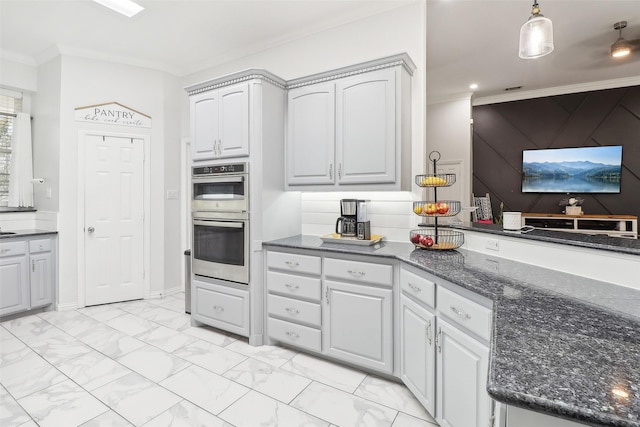 kitchen featuring double oven, dark stone countertops, hanging light fixtures, ornamental molding, and gray cabinetry