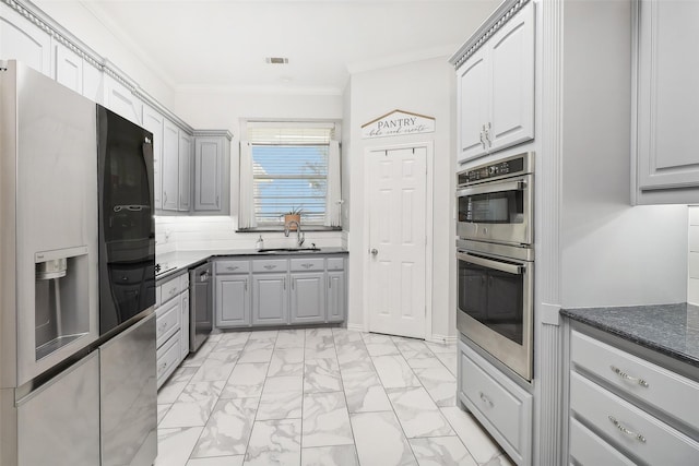 kitchen with crown molding, appliances with stainless steel finishes, sink, and gray cabinets