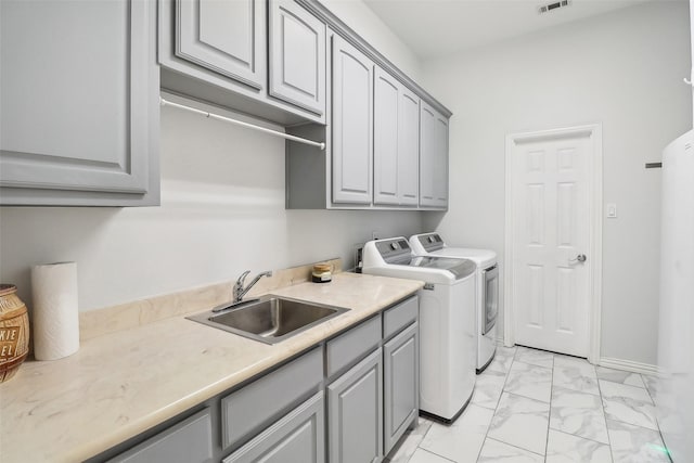 washroom featuring cabinets, washer and dryer, and sink