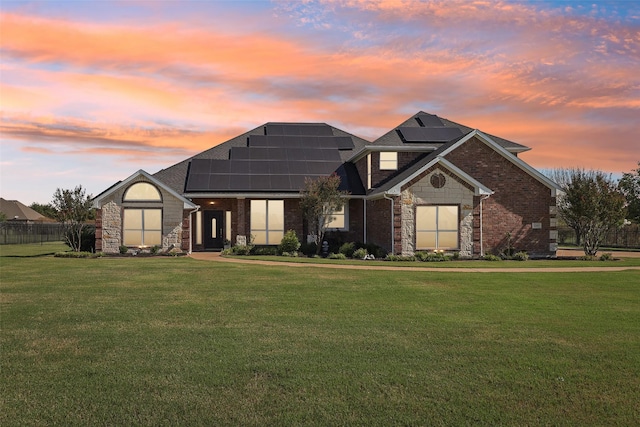 view of front of home featuring a yard and solar panels