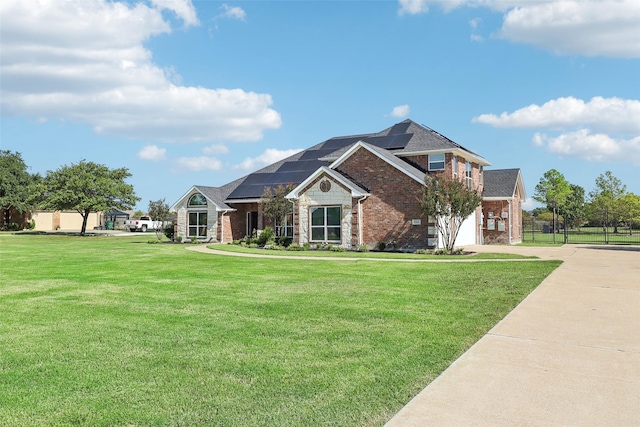 view of front of property featuring a front yard and solar panels