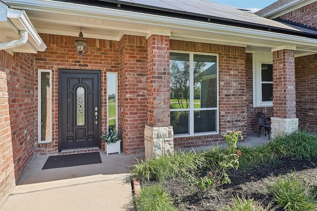 entrance to property with solar panels and a porch