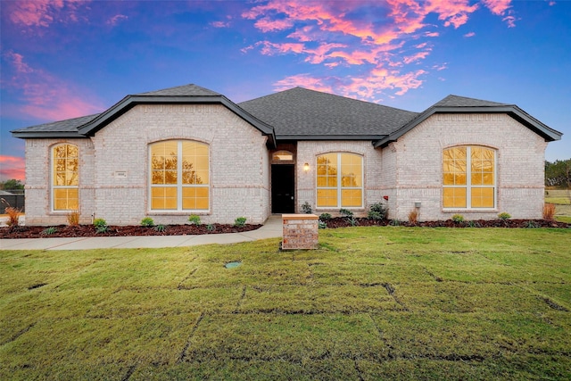 french country inspired facade featuring a lawn