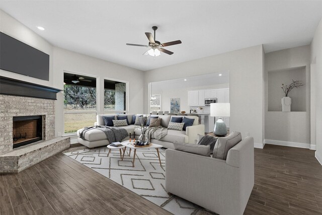 unfurnished living room with dark hardwood / wood-style floors, a brick fireplace, and ceiling fan