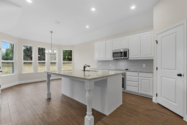 kitchen featuring dark wood-type flooring, white cabinets, sink, light stone countertops, and appliances with stainless steel finishes