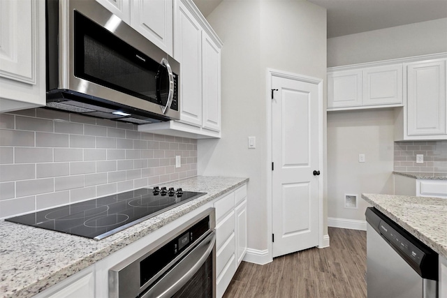 kitchen featuring appliances with stainless steel finishes, light hardwood / wood-style floors, and white cabinetry