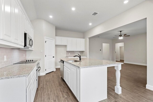 kitchen featuring light stone countertops, white cabinetry, sink, pendant lighting, and wood-type flooring