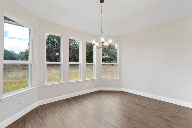 unfurnished dining area with hardwood / wood-style floors and a chandelier