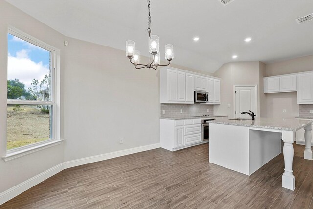 unfurnished bedroom with carpet flooring, ensuite bathroom, ceiling fan, and lofted ceiling