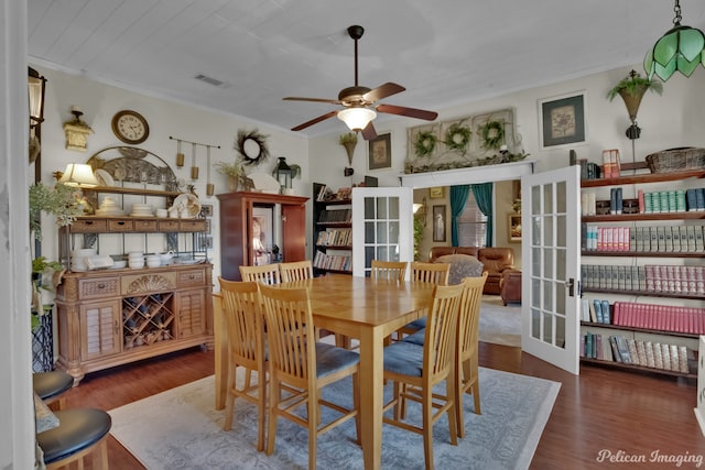 dining space featuring ceiling fan, french doors, crown molding, and dark wood-type flooring