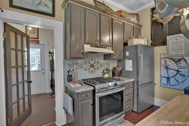 kitchen featuring crown molding, dark wood-type flooring, and stainless steel appliances