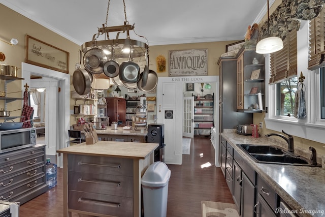 kitchen with a center island, wood counters, dark wood-type flooring, sink, and dark brown cabinetry