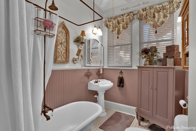 bathroom with tile patterned floors, a tub, and toilet