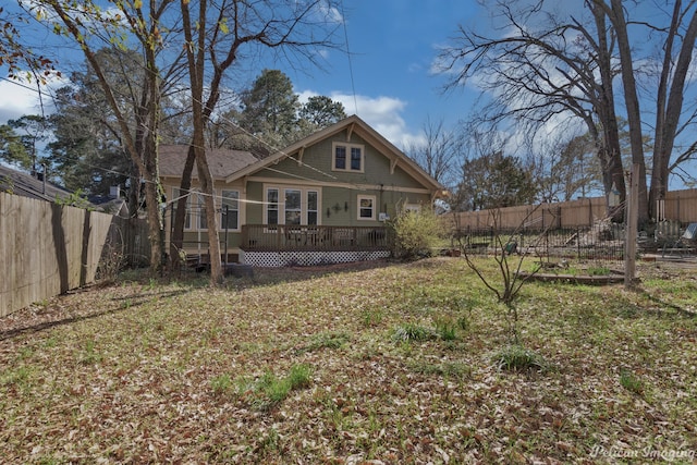 back of house featuring a deck and a yard