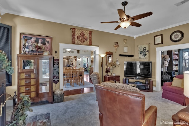 living room featuring ceiling fan, crown molding, and a healthy amount of sunlight