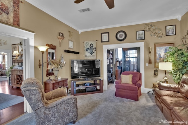 living room featuring wood-type flooring, ceiling fan, and crown molding