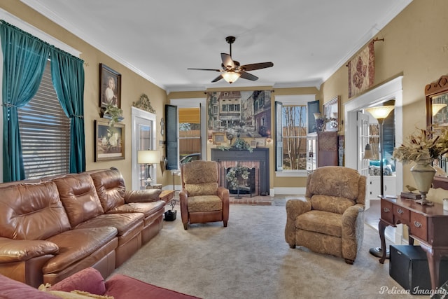 carpeted living room featuring ceiling fan, a fireplace, and crown molding