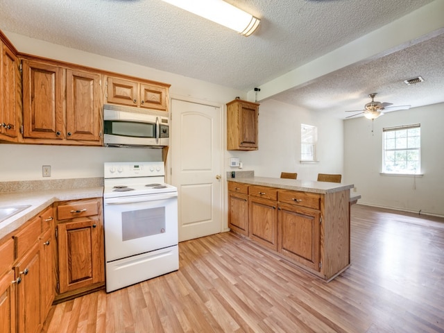 kitchen with ceiling fan, white range with electric cooktop, light wood-type flooring, and kitchen peninsula