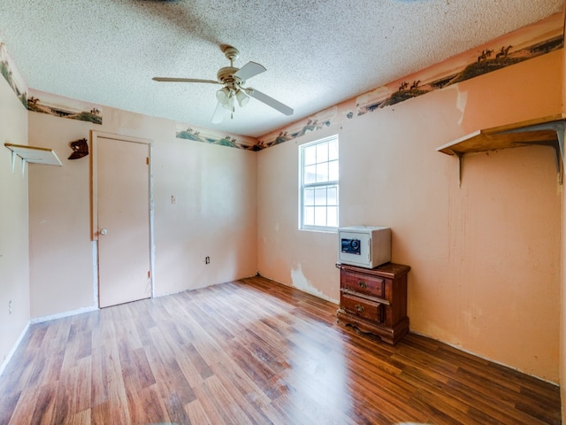 unfurnished bedroom with a textured ceiling, ceiling fan, and hardwood / wood-style flooring