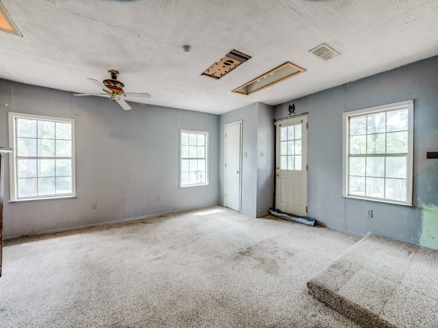 carpeted empty room featuring a textured ceiling and ceiling fan