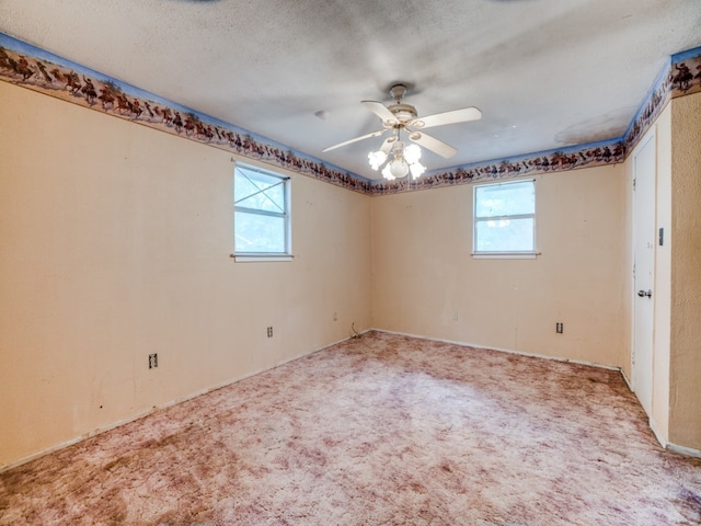 carpeted spare room featuring ceiling fan and a textured ceiling