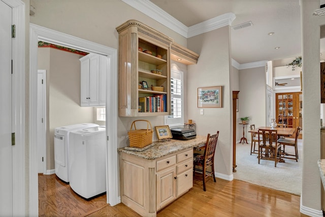 interior space featuring crown molding, washer and dryer, and light hardwood / wood-style floors