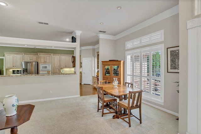 carpeted dining area with crown molding