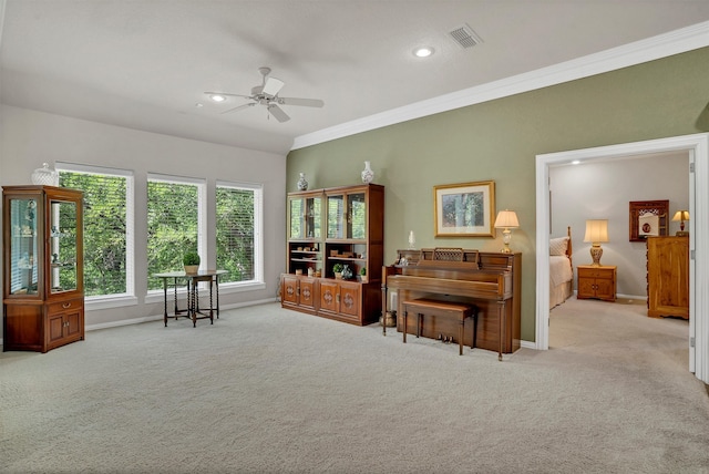 living area featuring light colored carpet, ceiling fan, and ornamental molding