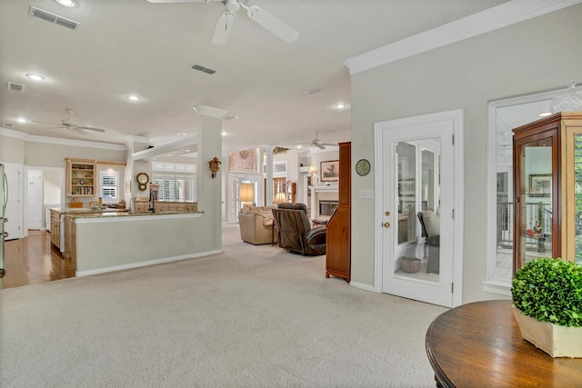 carpeted living room featuring crown molding and ceiling fan