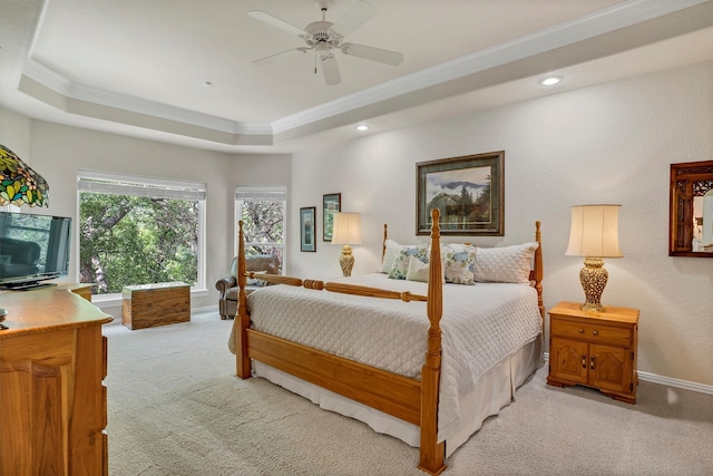 carpeted bedroom featuring a raised ceiling, ceiling fan, and ornamental molding