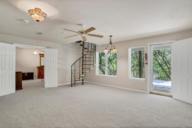 unfurnished room featuring light carpet and ceiling fan with notable chandelier