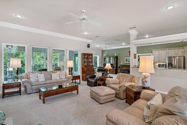 living room featuring ceiling fan, light colored carpet, ornamental molding, and a wealth of natural light