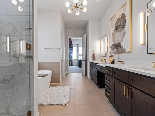 bathroom featuring plus walk in shower, tile walls, tile patterned flooring, a chandelier, and vanity