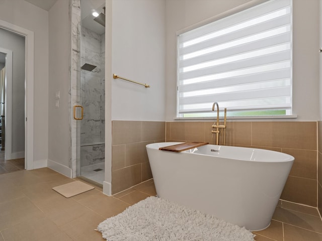 bathroom featuring separate shower and tub, tile walls, and tile patterned flooring