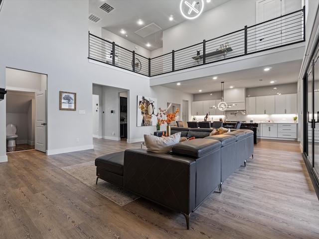 living room with hardwood / wood-style floors and a towering ceiling