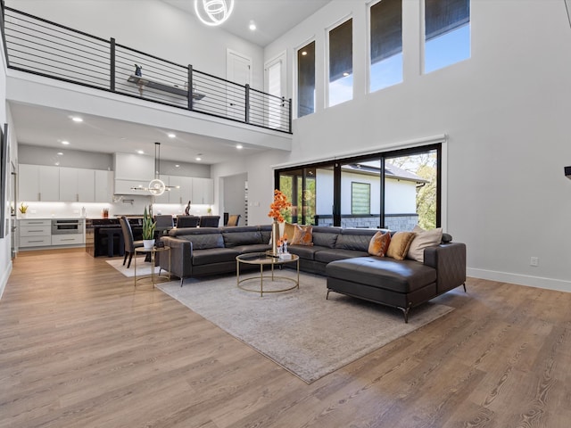 living room featuring a high ceiling and light wood-type flooring