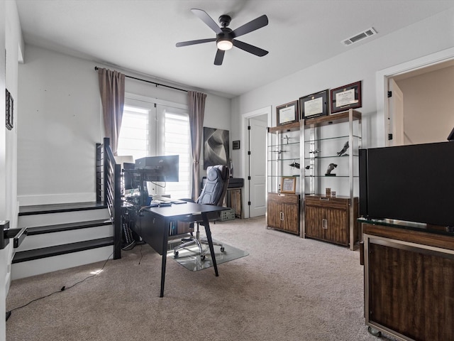 carpeted office with a ceiling fan and visible vents