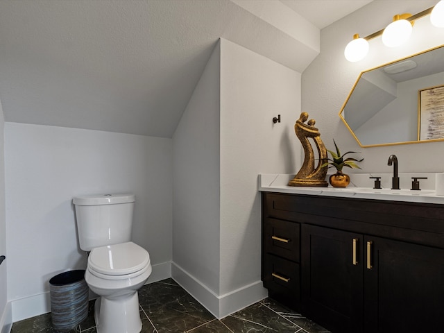 bathroom with vaulted ceiling, vanity, and toilet