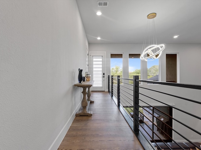 corridor featuring an inviting chandelier and hardwood / wood-style floors