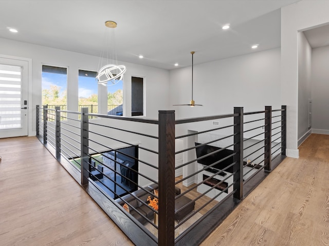 hall featuring an inviting chandelier and light wood-type flooring