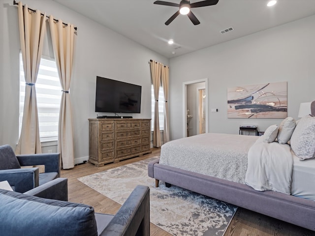 bedroom featuring light hardwood / wood-style flooring, ensuite bath, and ceiling fan