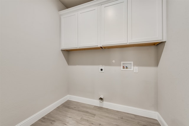 washroom featuring washer hookup, hookup for an electric dryer, cabinets, light hardwood / wood-style flooring, and gas dryer hookup