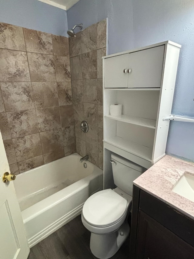 full bathroom featuring tiled shower / bath, vanity, toilet, and hardwood / wood-style flooring