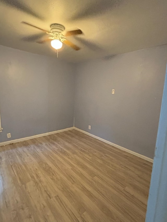 unfurnished room with ceiling fan and hardwood / wood-style flooring